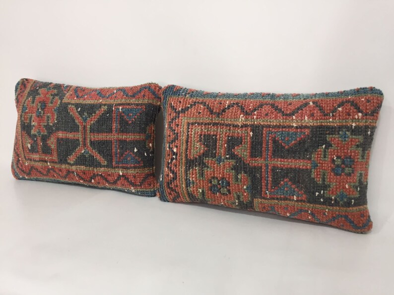 May include: Two rectangular throw pillows with a traditional Turkish kilim pattern in shades of red, blue, green, and black.