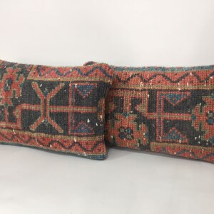 May include: Two rectangular throw pillows with a traditional Turkish kilim pattern. The pillows are made of woven fabric with a red, blue, and green color scheme. The pillows are in a horizontal position.