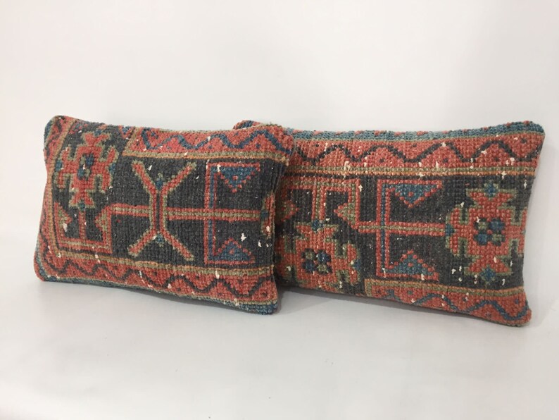 May include: Two rectangular throw pillows with a traditional Turkish kilim pattern. The pillows are made of woven fabric with a red, blue, and green color scheme. The pillows are in a horizontal position.