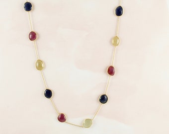 May include: A gold chain necklace with oval-shaped gemstones in shades of blue, red, and yellow.