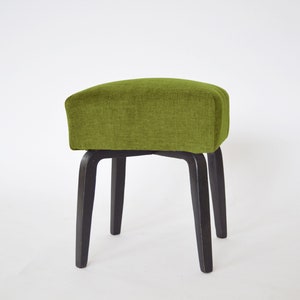 May include: A green upholstered stool with four black wooden legs.