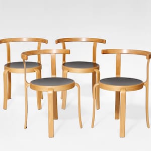 Könnte beinhalten: Ein Set aus drei Keramikbechern mit einer gesprenkelten, cremefarbenen Glasur. Jeder Becher hat ein anderes handgemaltes Blumendesign in Blau-, Grün- und Gelbtönen. Die Becher haben eine schlichte, moderne Form.