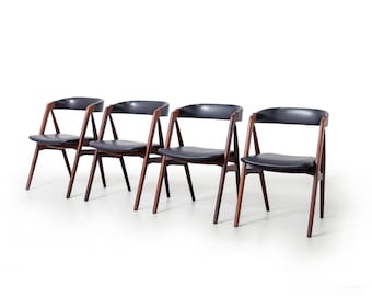 May include: Four black leather dining chairs with dark wood frames. The chairs have a simple, mid-century modern design.