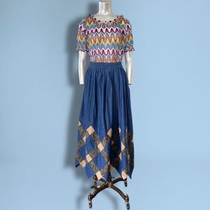 Puede incluir: Una taza de cerámica blanca con un asa negra y el texto "But First, Coffee" en negro y negrita. La taza está sobre una superficie blanca.