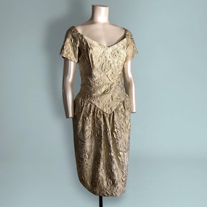 Vestido de fiesta de lamé dorado de los años 80, manga corta, cintura vasca, estampado floral metálico con remolinos, glamuroso, textura vintage y relieve.