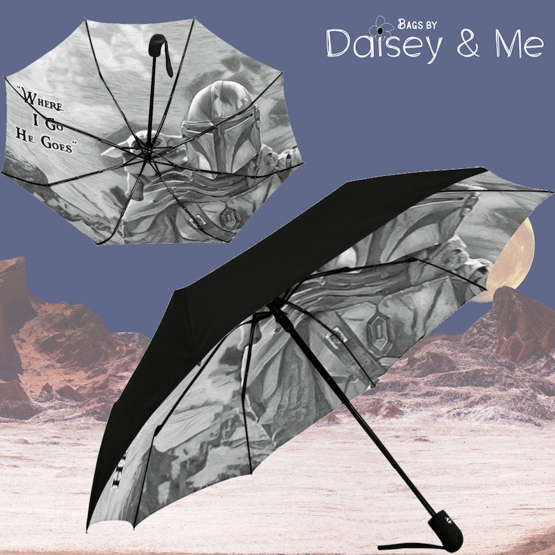 May include: A black and white umbrella with a graphic of a Mandalorian character and the text "Where I Go He Goes".