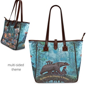 May include: A blue and brown tote bag with a multi-sided design featuring characters from the movie Brave. The bag has brown leather handles and a zipper closure. The front of the bag features a bear and a girl with a bow and arrow. The text "Be BRAVE for Destiny is Within" is printed on the bottom of the bag.
