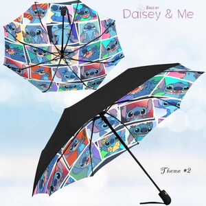 May include: Two open umbrellas with a black exterior and a colourful interior featuring a collage of Stitch from Lilo & Stitch. The umbrellas have a black handle and a metal frame. The text "Bags by Daisey & Me" and "Theme #2" are visible.