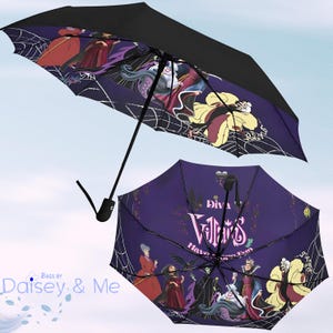 May include: A purple and black umbrella featuring a design of Disney Villains, including Maleficent, Ursula, Cruella de Vil, and the Evil Queen. The umbrella has the text "Diva Villains Have More Fun".
