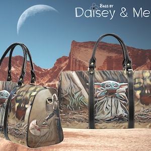 May include: Two brown and black travel bags with a graphic print of a character from the Star Wars franchise. The character is a small, green, humanoid creature with large ears. The bags have black leather handles and gold accents. The background is a desert landscape with a crescent moon in the sky.