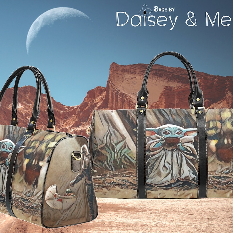 May include: Two brown and black travel bags with a graphic print of a character from the Star Wars franchise. The character is a small, green, humanoid creature with large ears. The bags have black leather handles and gold accents. The background is a desert landscape with a crescent moon in the sky.