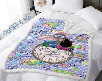 May include: A purple and white fleece blanket with a whimsical Alice in Wonderland theme. The blanket features a repeating pattern of teacups, teapots, and polka dots. A large pocket watch with a blue cat and a black hat is in the center of the blanket. The watch face reads "How long is forever? Sometimes just one second."