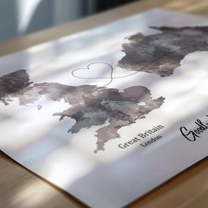 May include: A grayscale map of Great Britain with a dotted line connecting two locations, forming a heart shape. The words "Great Britain" and "London" are printed on the map. The overall theme is travel and relationships.