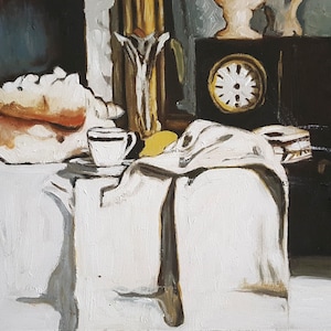 Könnte beinhalten: Ein Stillleben mit einer weißen Muschel, einer weißen Teetasse und Untertasse, einem weißen Tuch, einer schwarzen Uhr und einer gelben Zitrone auf einer weißen Tischdecke.