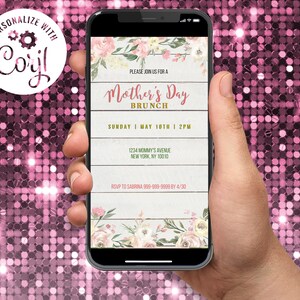 May include: A smartphone screen shows a Mother's Day Brunch invitation. The design includes floral elements, a wooden plank backdrop, and the text "Mother's Day Brunch." The invitation provides date, time, and RSVP details. The phone is held in a hand.