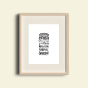 May include: A black and white drawing of a tall, layered hamburger. The drawing is framed in a light wood frame.