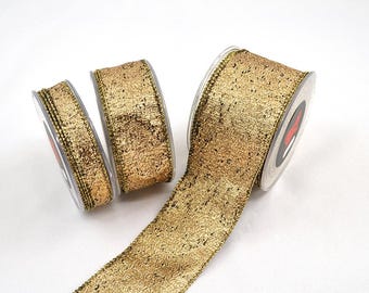 May include: Gold ribbon spools with a textured, metallic finish. The ribbon has a decorative edge and is ideal for crafts, gift wrapping, or holiday decorations. The spools are on a white background.