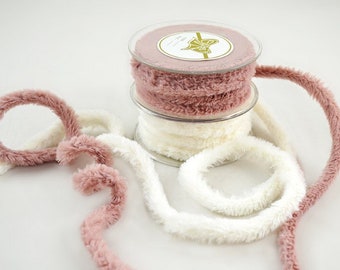 May include: Two spools of fuzzy ribbon, one pink and one white. The ribbon is soft and fluffy, perfect for adding a touch of whimsy to crafts and gifts.