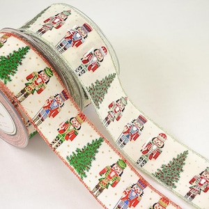 Puede incluir: Dos rollos de cinta navideña con fondo blanco y un patrón de cascanueces y árboles de Navidad. Una cinta tiene un borde rojo y la otra un borde verde.