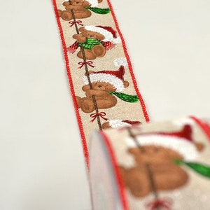 Orsetto marrone con cappello di Babbo Natale e sciarpa verde in una corda con fiocchi rossi e nastro stampato tagliato su misura