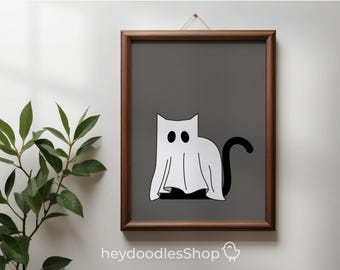 May include: A framed print featuring a whimsical illustration of a cat dressed as a ghost. The cat is white with black eyes and a black tail, set against a gray background. The frame is brown, and the print is hanging on a white wall.