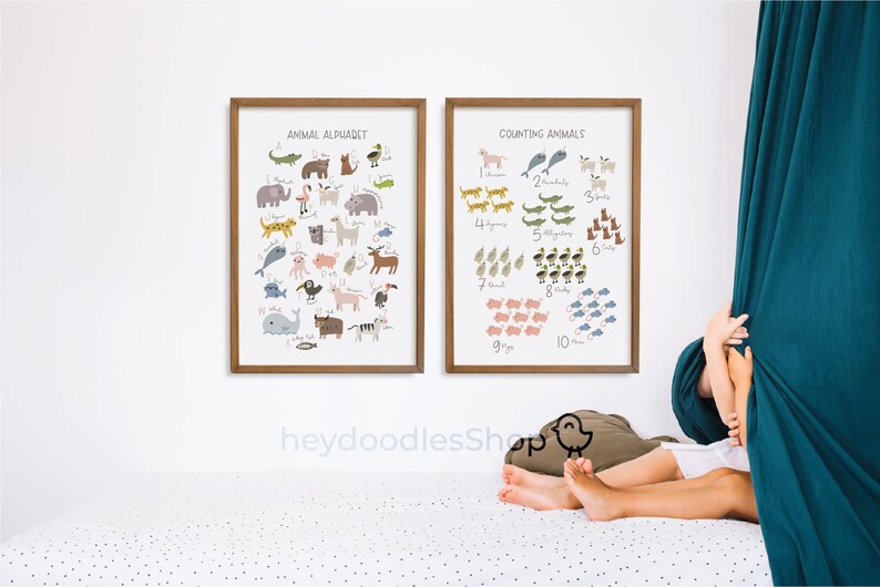 Op de afbeelding: Twee ingelijste educatieve posters voor kinderen. De poster aan de linkerkant heeft de titel "Animal Alphabet" en toont een kleurrijke illustratie van dieren van A tot Z. De poster aan de rechterkant heeft de titel "Counting Animals" en toont een kleurrijke illustratie van dieren in groepen van 1 tot 10.