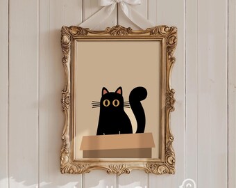 Peut inclure: Impression artistique encadrée d'un chat noir sortant d'une boîte en carton. Le chat a de grands yeux jaunes et une queue recourbée. Le cadre est doré et orné, suspendu par un nœud blanc. Le texte "heydoodlesShop" est en bas.