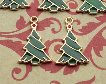 May include: Six gold-tone Christmas tree charms with green enamel and red star accents. The charms are arranged on a patterned background.