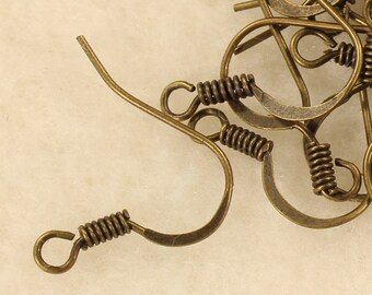 May include: A pile of antique brass earring hooks with spring closures. The hooks are in various positions, showing the different angles of the design.