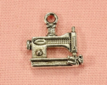 May include: Silver charm in the shape of a sewing machine. The charm has a detailed design and is perfect for adding to a bracelet or necklace.