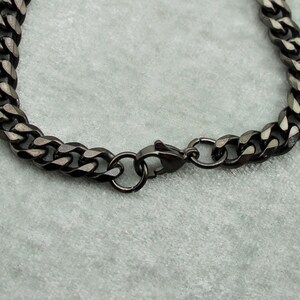 May include: A black chain bracelet with a lobster clasp closure.