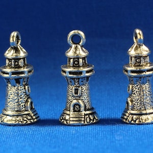 May include: Three silver-toned lighthouse charms with intricate details. Each charm features a small, detailed lighthouse with a domed roof and a window. The charms are perfect for adding a nautical touch to jewelry or crafts.