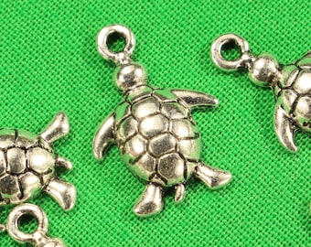 May include: Six silver turtle charms with a textured shell design. The charms have a loop at the top for attaching to jewelry or other crafts.