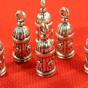 May include: Six silver-toned metal charms shaped like fire hydrants. The charms have a detailed design and are perfect for jewellery making or crafting.