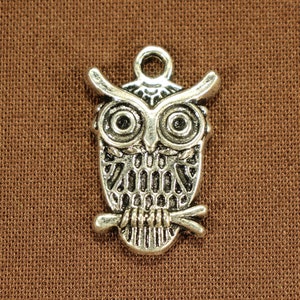 May include: Silver owl charm with detailed wings and eyes. The owl is perched on a branch.