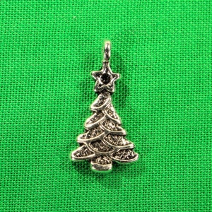 May include: Silver charm in the shape of a Christmas tree with a star on top.