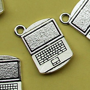 May include: A set of silver-toned laptop charms. The charms are detailed with a screen, keyboard, and trackpad.