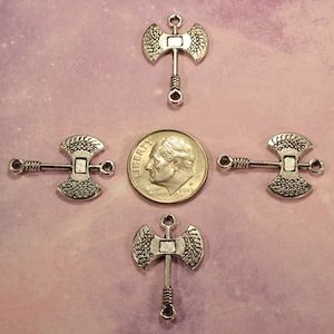 May include: Four silver axe charms with a twisted wire handle. The charms are about the size of a US dime.