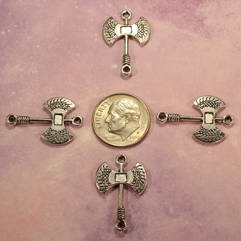 May include: Four silver axe charms with a twisted wire handle. The charms are about the size of a US dime.