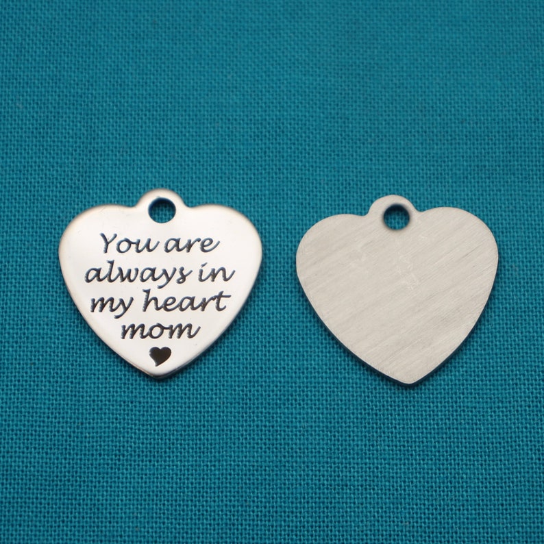 May include: Two silver heart-shaped charms. One charm has the inscription "You are always in my heart mom".