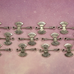 May include: Twelve silver axe-shaped charms with a decorative design. Each charm has two loops for attaching to jewelry or other crafts.