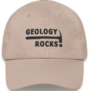 May include: A tan baseball cap with black embroidery that reads "Geology Rocks!" with a pickaxe graphic above the text.