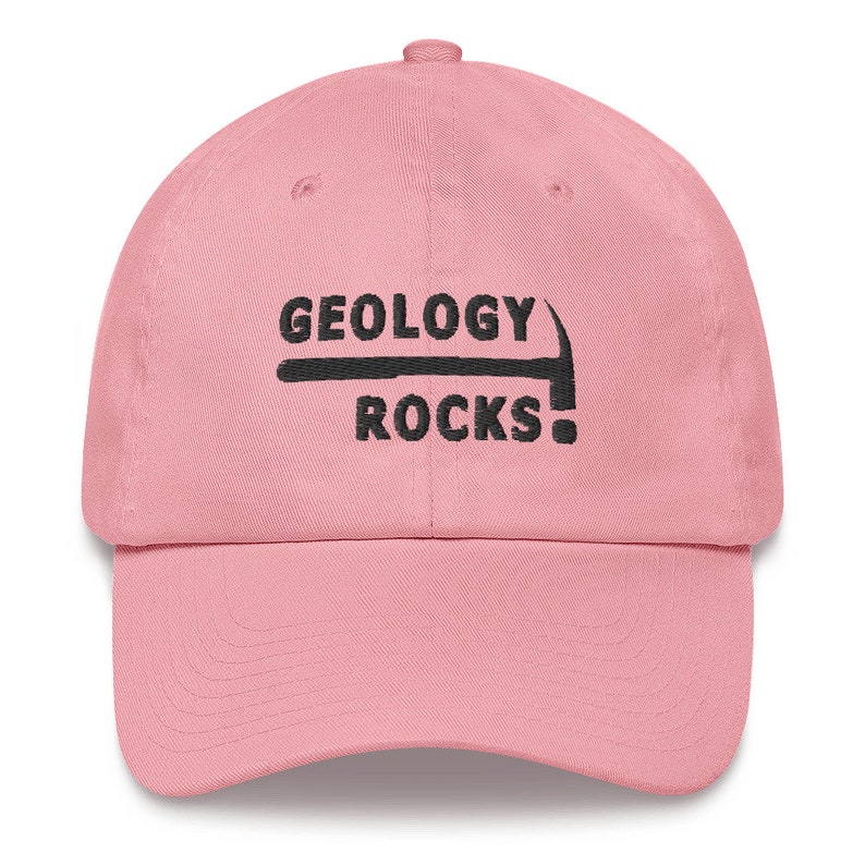 Puede incluir: Gorra de b&eacute;isbol rosa con bordado negro que dice "Geology Rocks!" con un gr&aacute;fico de pico.