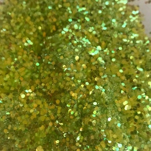 Puede incluir: Primer plano de un montón de purpurina verde con brillo iridiscente.