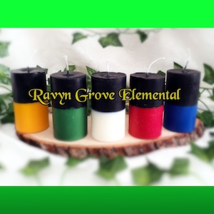May include: Five pillar candles with black tops and different colored bottoms. The candles are labeled "Ravyn Grove Elemental".
