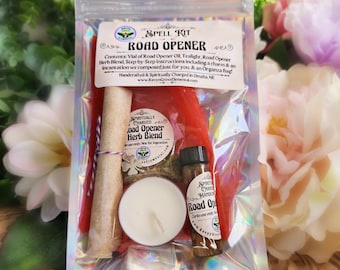 May include: A Road Opener spell kit in a holographic pouch containing a red candle, a white tealight, a vial of oil, a packet of herb blend, a rolled scroll with a clover charm, and a label listing contents and Omaha, NE origin.