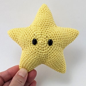 May include: A yellow crocheted star with black button eyes.