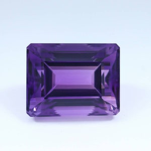 May include: A deep purple amethyst gemstone cut in a rectangular emerald shape.