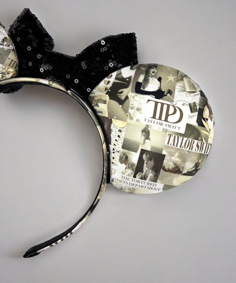 May include: Black and white mouse ears headband with a black sequin bow. The ears are covered in a collage of images and text, including the words "Taylor Swift" and "The Tortured Arts Department".
