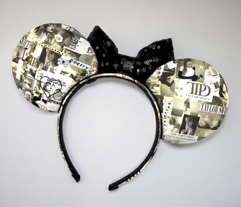May include: Black and white collage mouse ears with a black sequin bow. The ears feature a collage of images and text, including "Taylor Swift" and "poetry".